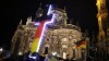 Manifestación del grupo islamófobo Pegida con una cruz iluminada con la bandera de Alemania. AFP
